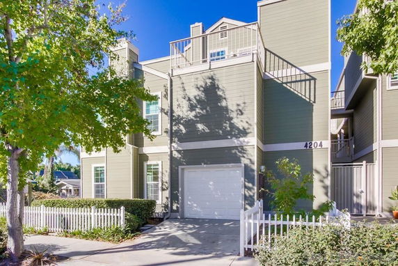 Front view of a multi-story house with a garage and balcony.