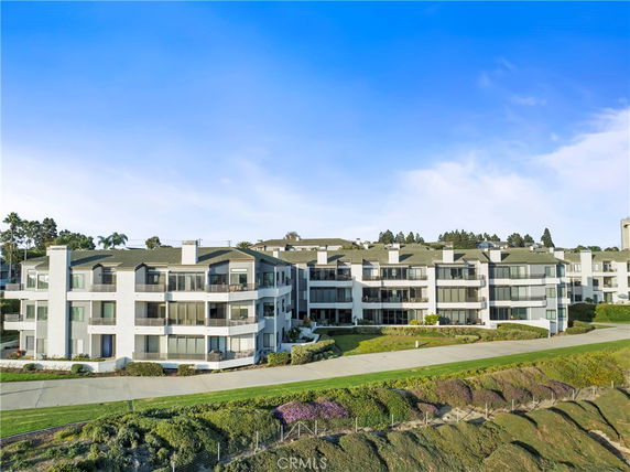 Front view of a multi-story apartment complex with large windows and balconies.