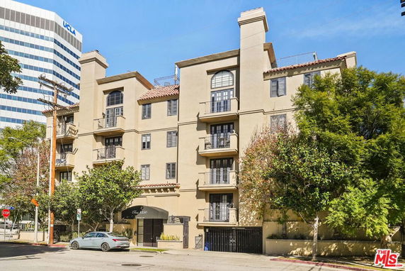 Front view of a multi-story apartment building with balconies.