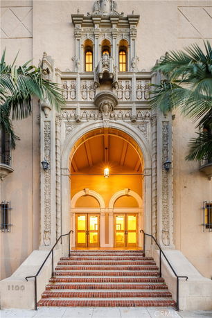 Ornate front entrance of a historic building with detailed stone arch and steps.