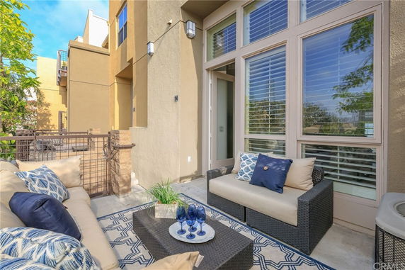 View of a modern house with tall windows and a patio area.