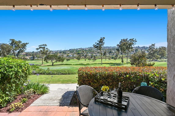 Panoramic view from a building overlooking a golf course and surrounding landscape.