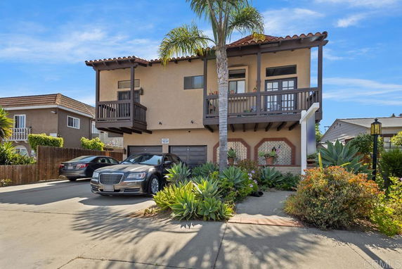 Front view of a two-story house with a balcony and garage.