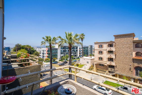 Panoramic view overlooking a street with multiple buildings and palm trees.