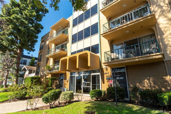 Front view of a multi-story apartment building with balconies.