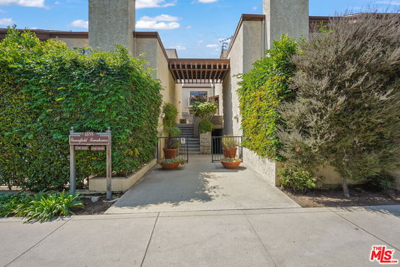 Front view of a multi-story townhouse complex with a gated entrance.