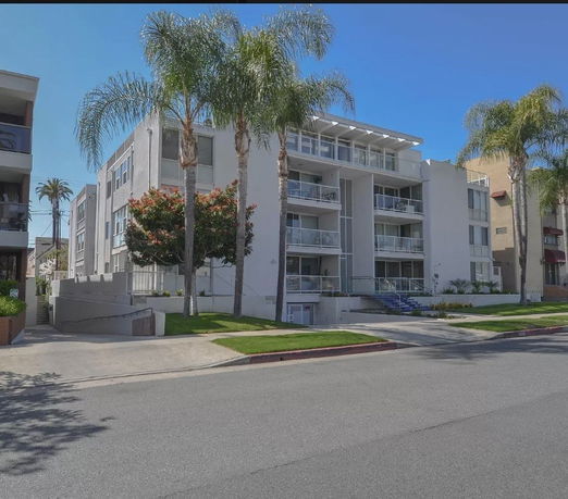 Front view of a multi-story modern apartment building with balconies.