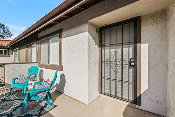 Front view of a house entry with a security door and adjacent windows.