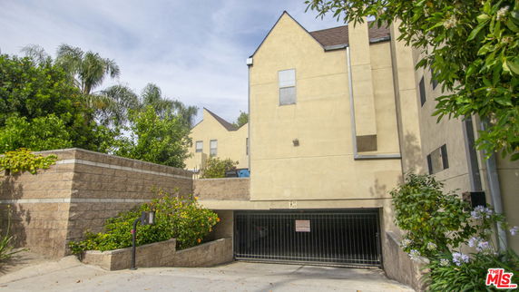 Outdoor view of building with a gated parking entrance.