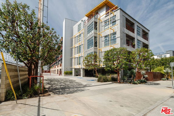 Front view of a modern multi-story building with large windows and yellow accents.