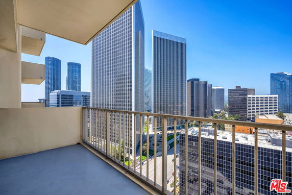 Balcony view of tall skyscrapers in an urban setting.