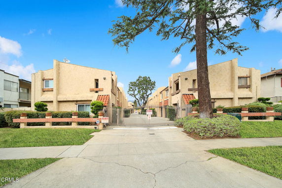 Front view of a two-story residential complex with a gated entrance.