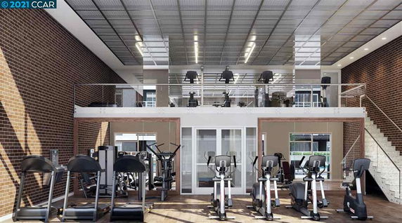 Interior view of a gym area with exercise equipment and a mezzanine level.