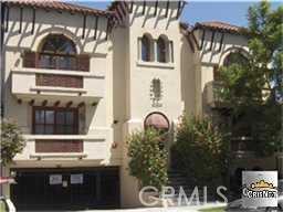 Front view of a multi-story building with balconies and arched windows.