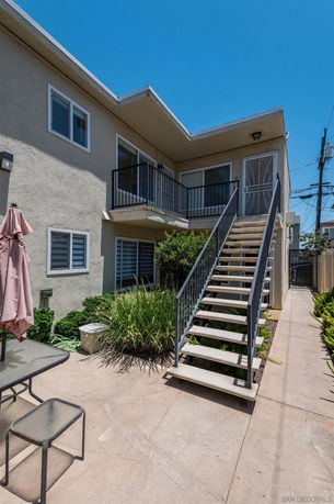 Front view of a two-story building with an external staircase leading to the upper level.