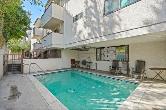 Outdoor swimming pool adjacent to a multi-story building.