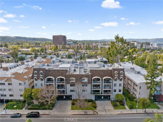 Front view of a multi-story residential building with arched windows and balconies.