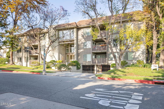 Front view of a multi-story apartment building with balconies.
