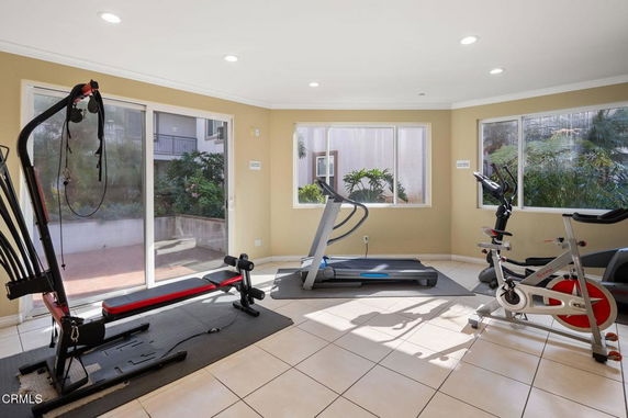 Indoor gym area with exercise equipment and large windows