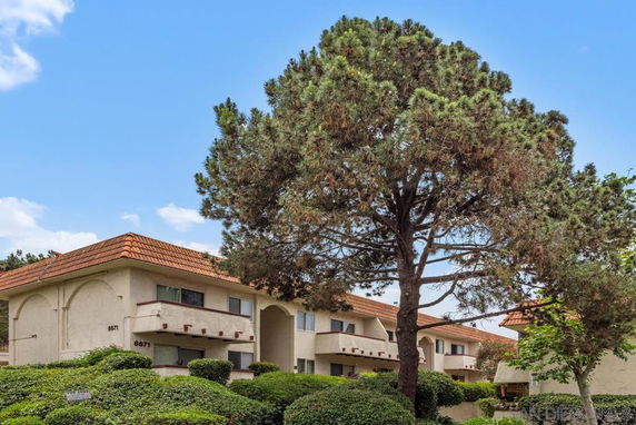 Front view of a multi-story residential building with a tile roof.