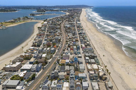 Panoramic view of a coastal area with numerous buildings and a beach.