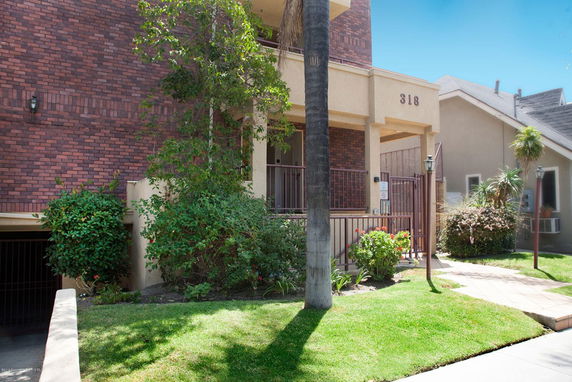 Front view of a building with brick and beige exterior and entrance gate.