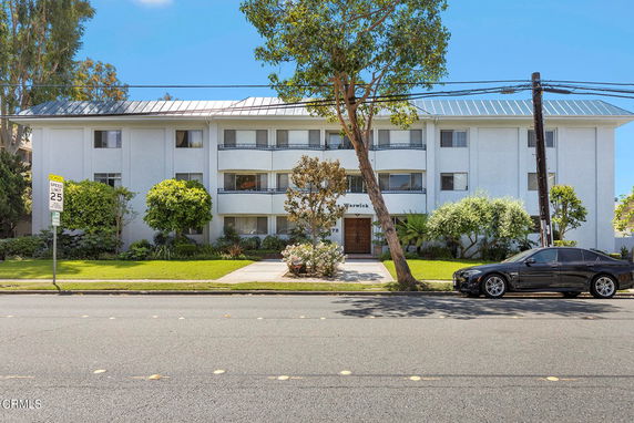 Front view of a three-story apartment building with balconies.