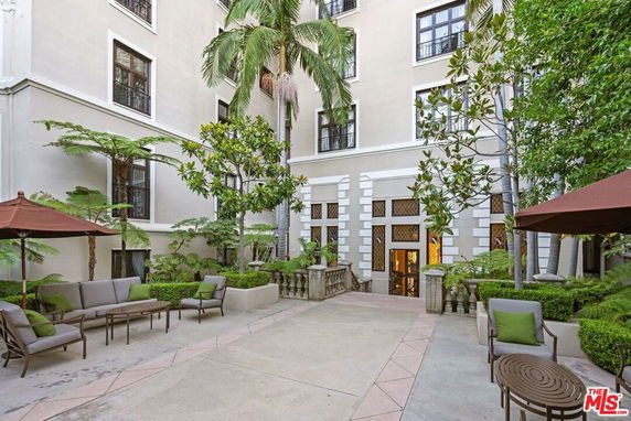 Courtyard view of a multi-story building with outdoor seating and greenery.