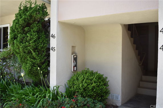 Front view of a building entrance with stairs leading to the upper floor, with unit numbers 45 and 46 visible.