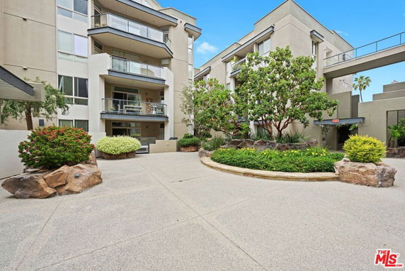Front view of a multi-story apartment building with balconies.