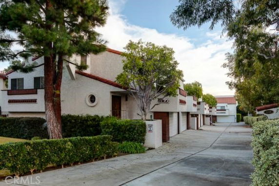 Front view of a row of residential townhouses with garages underneath.