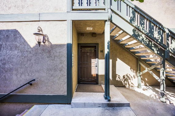 Entrance view of a residential unit with stairs and a doorway.
