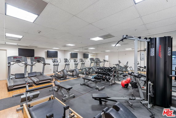 Indoor gym with various exercise equipment, including treadmills and weight machines.