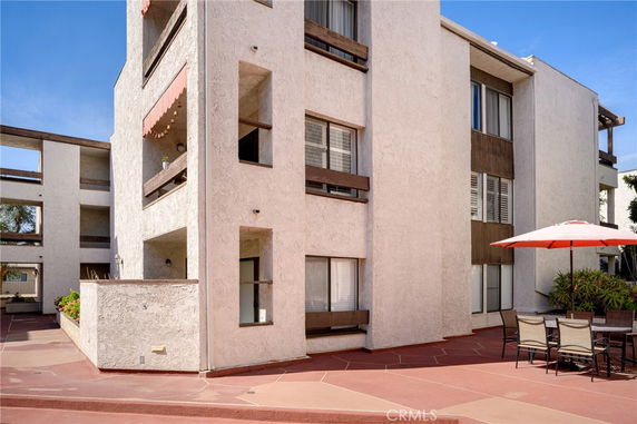 Front view of a multi-story building with balconies and outdoor seating.