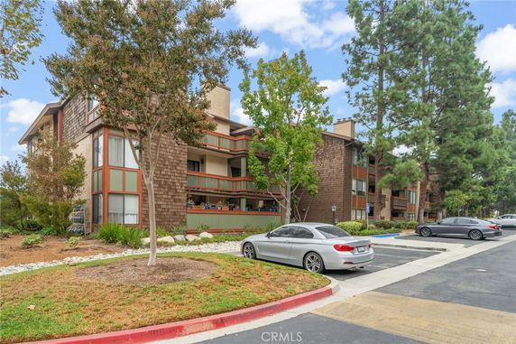 Front view of a multi-story residential building with wood siding and balconies.