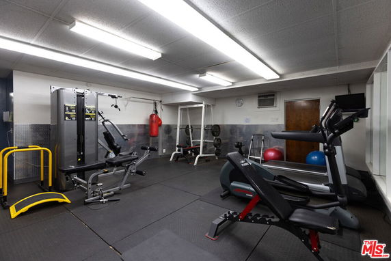 Indoor gym area with exercise equipment and machines.