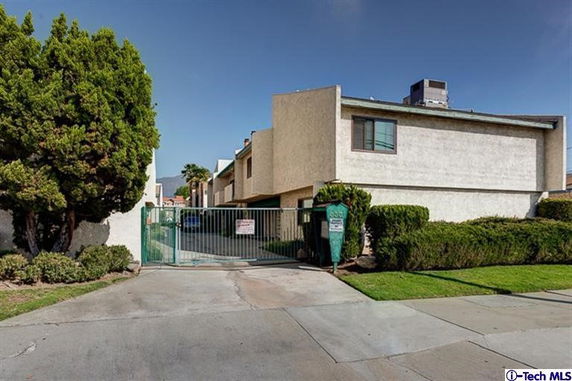 Front view of a multi-story residential building with gated entrance.