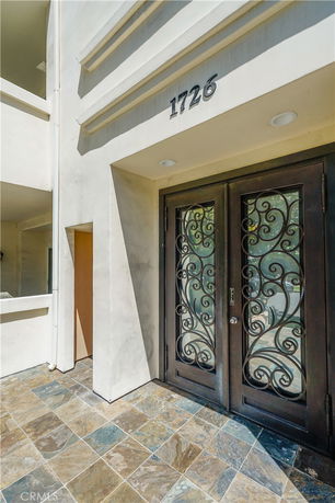 Front view of a building entrance with decorative doors and the number 1726 displayed above.