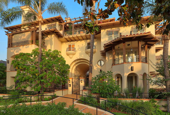 Front view of a multi-story house with balconies and arches.