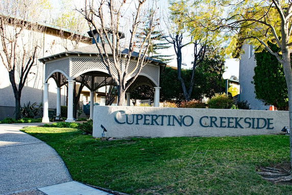 Front view of a building with a gazebo and sign reading 'Cupertino Creekside.'
