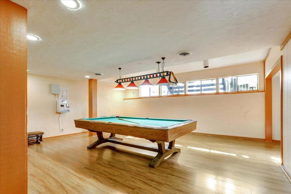 Room with a pool table and overhead lighting.