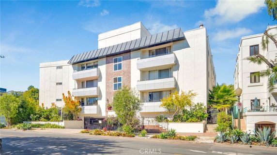 Front view of a multi-story apartment building with balconies and a modern design.