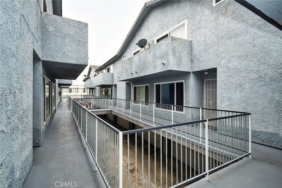 Exterior view of a multi-level apartment building with white railings and balconies.