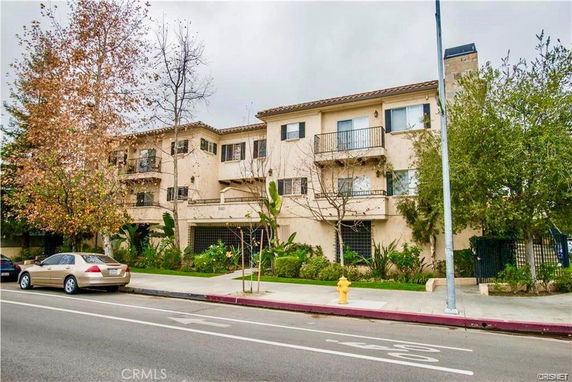 Front view of a three-story apartment building with balconies.