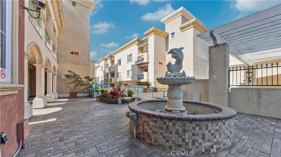 Front view of a multi-story building with a decorative fountain.