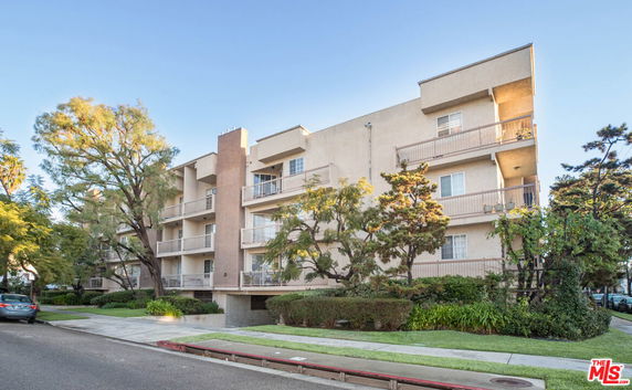 Front view of a multi-story apartment building with balconies.