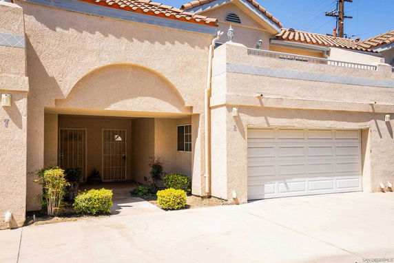 Front view of a house with an arched entrance and a double garage.