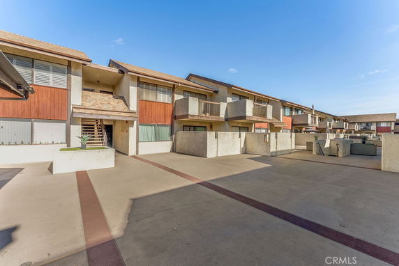 Front view of a row of multi-story townhouses with balconies.