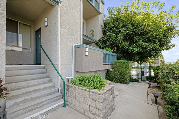 Front view of a multi-story building with a staircase leading to a doorway.
