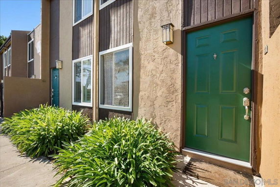 Front view of a house with a green door and large windows.